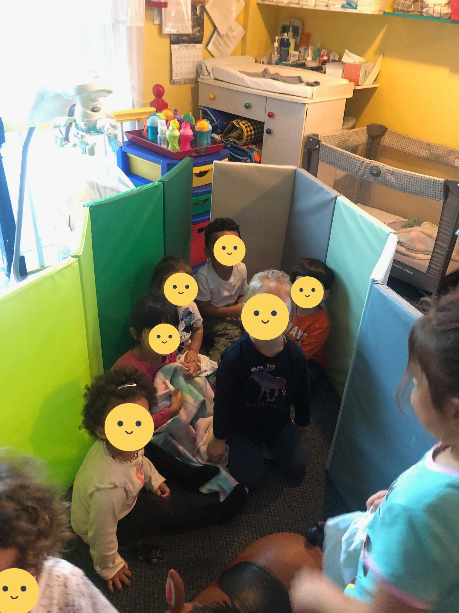 Children playing in a fort made of floor mats.